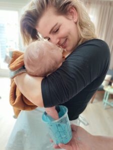 Moeder houdt haar kindje vast terwijl een handafdrukje wordt gemaakt